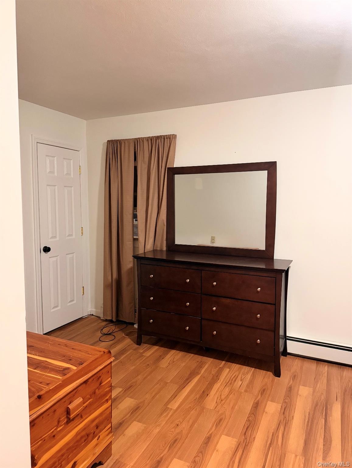 71 Crescent Street Yaphank, NY 11980 - Photo 11 of 22 a room with a dresser and a flat screen tv