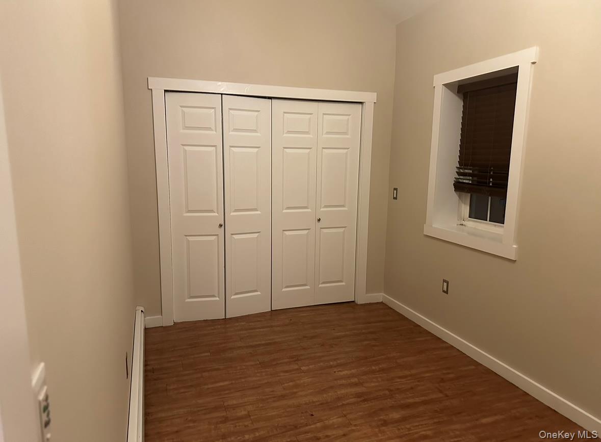 71 Crescent Street Yaphank, NY 11980 - Photo 21 of 22 a view of empty room with wooden floor and fan