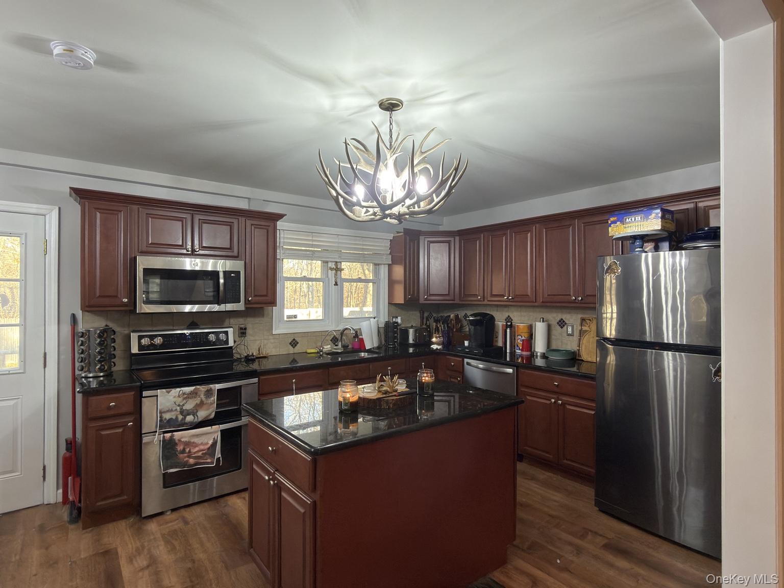 71 Crescent Street Yaphank, NY 11980 - Photo 6 of 22 a kitchen with refrigerator a stove a sink cabinets and a dining table