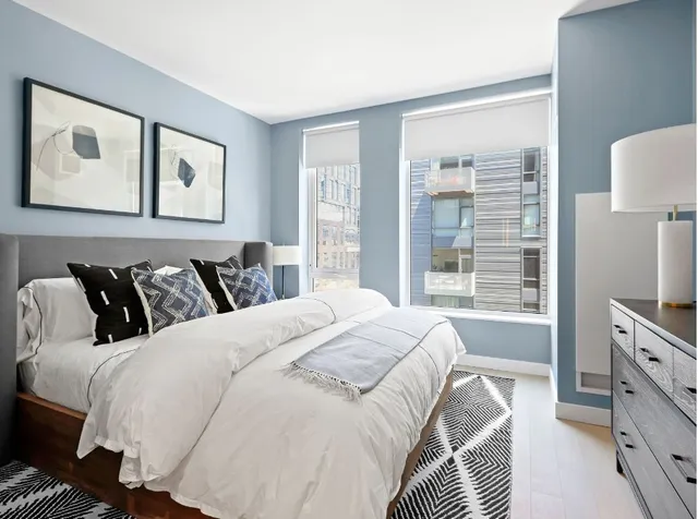 a bedroom with a bed and a flat tv screen on the dresser