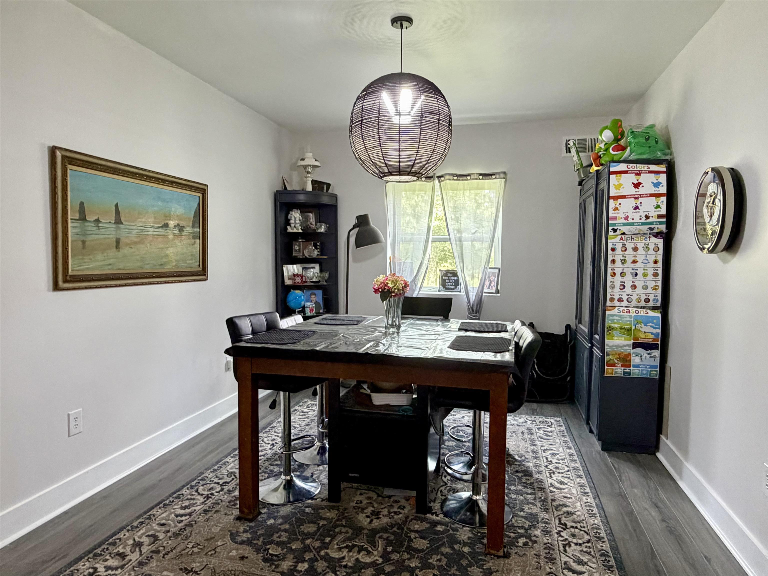3670 Peavine Road Middleton, TN 38052 - Photo 16 of 36 Dining area featuring a contemporary spherical pendant light fixture, wood-finish flooring, white baseboards, and a window with sheer curtains