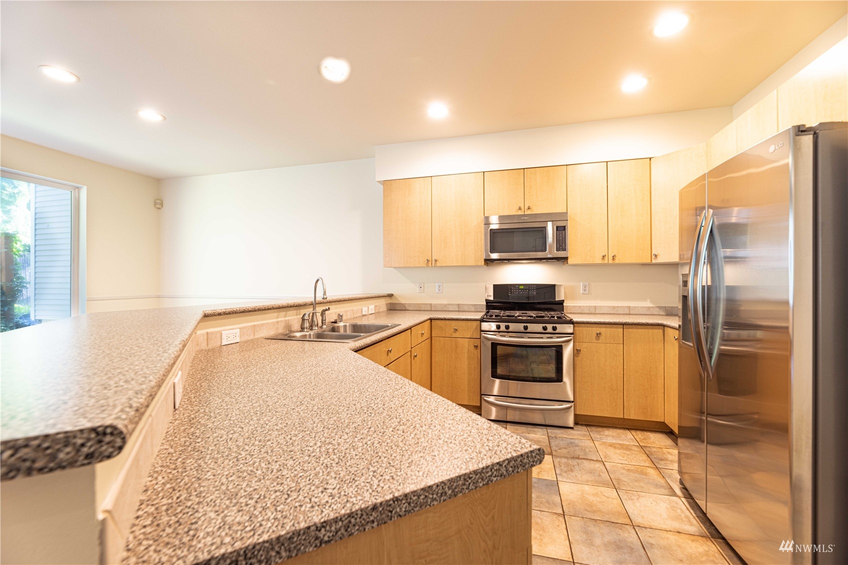 4911 Talbot Place South, Unit A Renton, WA 98055 - Photo 3 of 20 a kitchen with granite countertop a stove sink and refrigerator