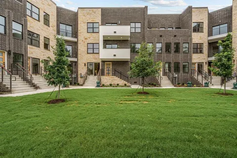 a front view of a residential apartment building with a yard