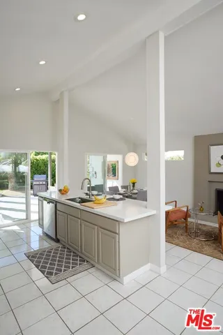 a kitchen with a sink and chairs