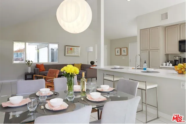 a dining room with furniture kitchen view and large windows