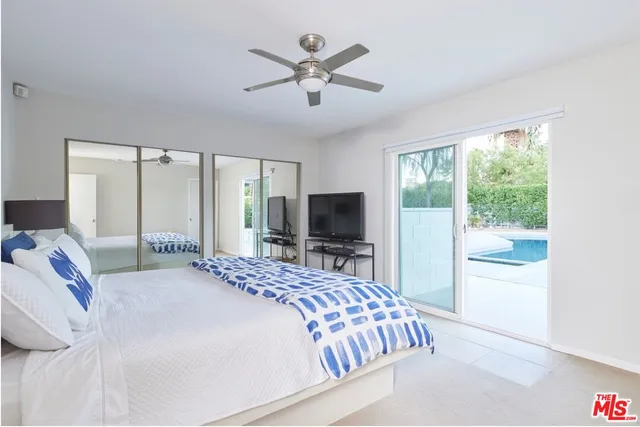 a bedroom with a large bed and a flat screen tv