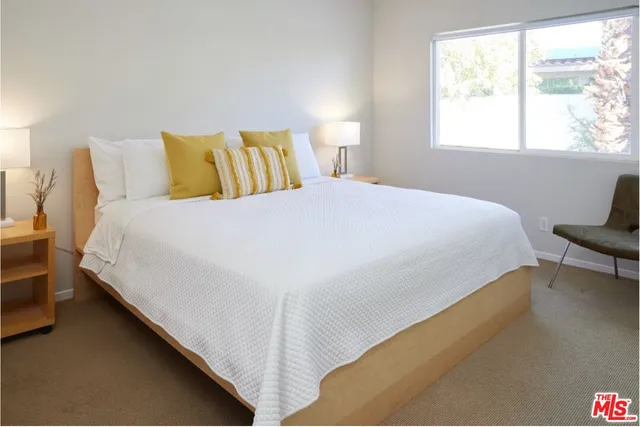 a large bed sitting in a bedroom next to a window