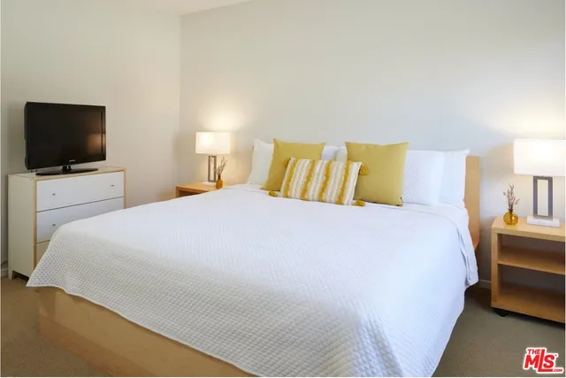 a bedroom with a bed and a flat screen tv