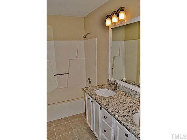 8920 New Windsor Place Raleigh, NC 27603 - Photo 14 of 25 a bathroom with a granite countertop sink and a mirror
