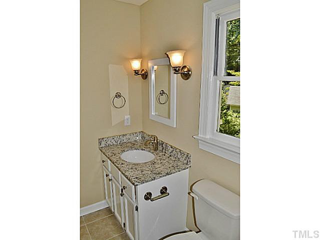 8920 New Windsor Place Raleigh, NC 27603 - Photo 17 of 25 a bathroom with a granite countertop sink a mirror and shower