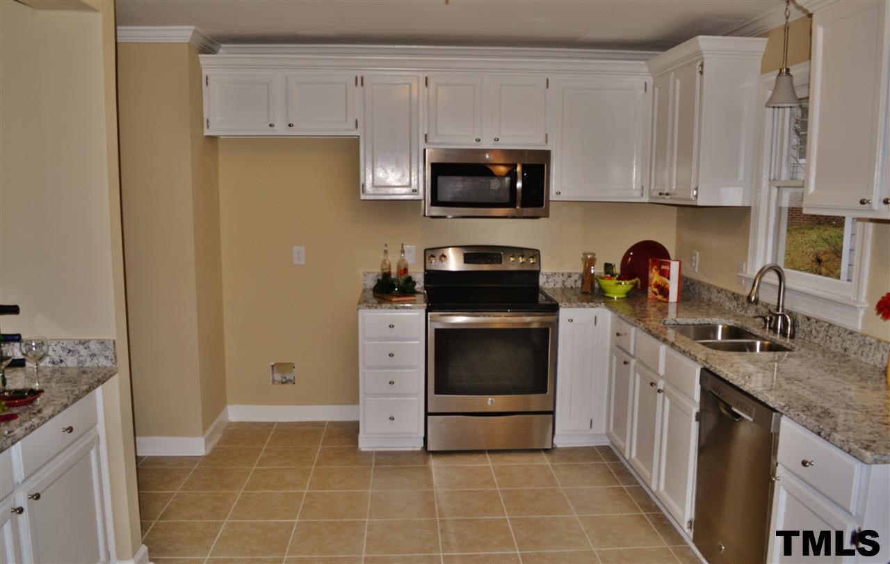 8920 New Windsor Place Raleigh, NC 27603 - Photo 9 of 25 a kitchen with stainless steel appliances a stove a sink and a refrigerator