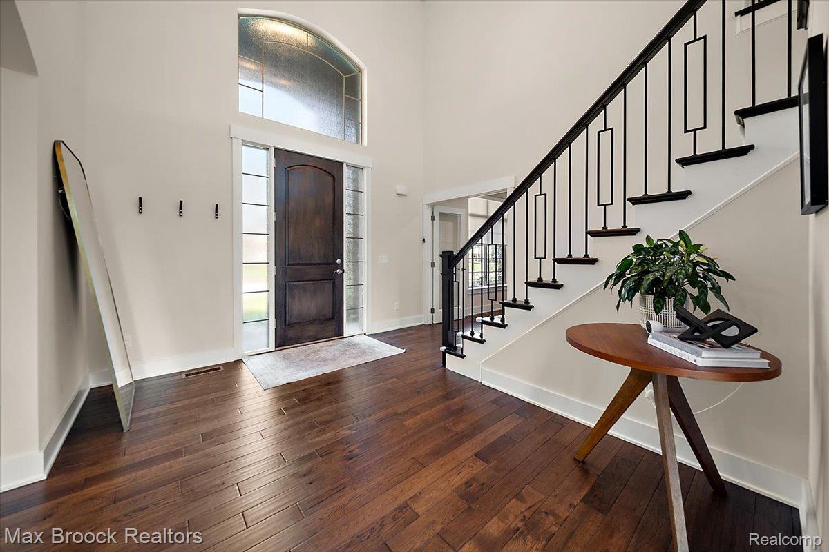 1942 Nottingham Drive Rochester, MI 48307 - Photo 7 of 97 Inviting entryway featuring dark wood-finish flooring, a grand arched window, and a dark wood paneled entry door with sidelights