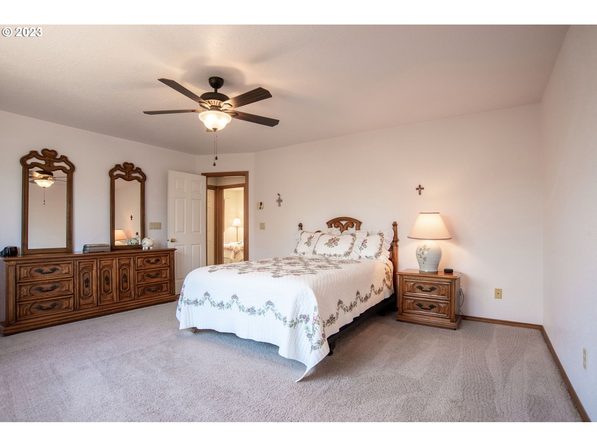 760 Northeast 24th Street Gresham, OR 97030 - Photo 14 of 34 a spacious bedroom with a bed and a chandelier