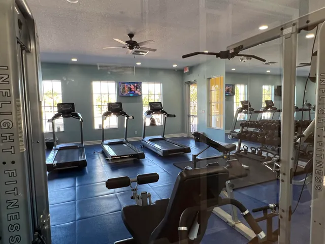 a living room with couches a dining table and a chandelier with kitchen view