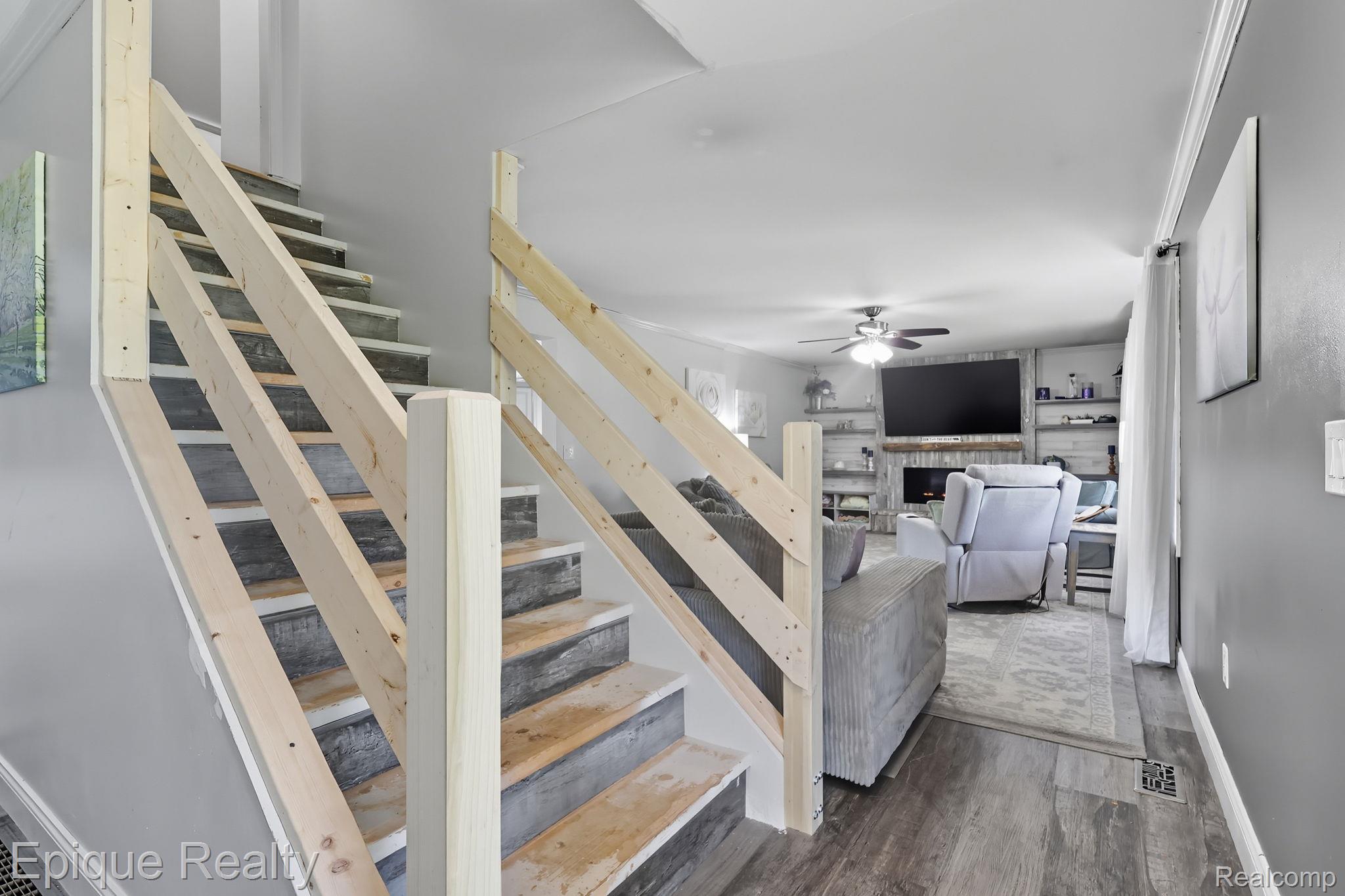 13265 Tibbets Road Memphis, MI 48041 - Photo 18 of 48 Stairs with a fireplace, wood finished floors, and ceiling fan