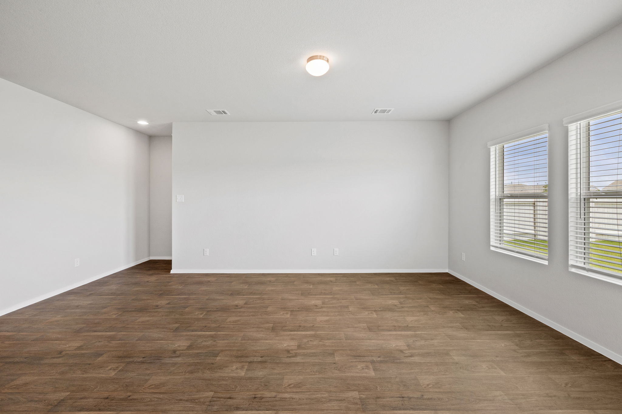 2460 Winding Creek Road Kyle, TX 78640 - Photo 7 of 20 Natural light streams into this generously proportioned interior, highlighting its durable wood-look flooring.