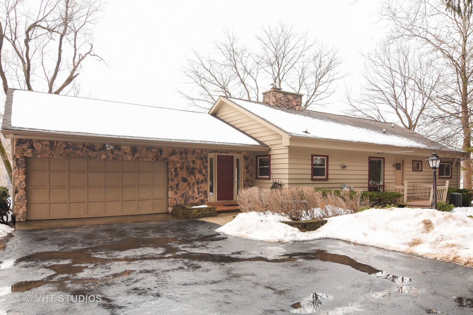 a front view of a house with a yard covered in snow