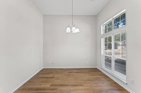 a view of a room with wooden floor and windows