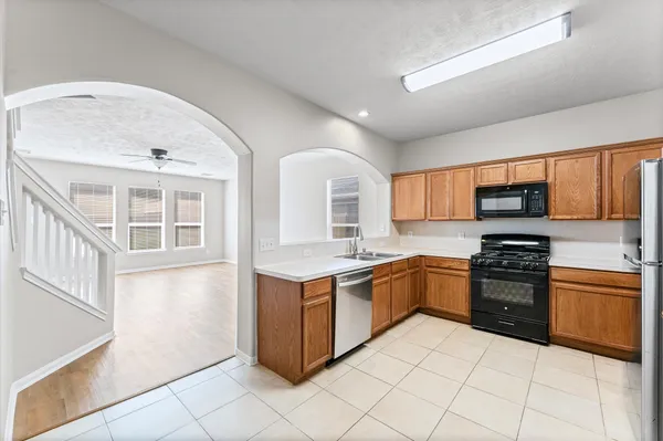 a kitchen with stainless steel appliances granite countertop a stove top oven a sink dishwasher and a refrigerator