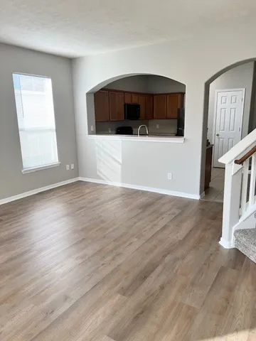 a view of a livingroom with wooden floor and staircase