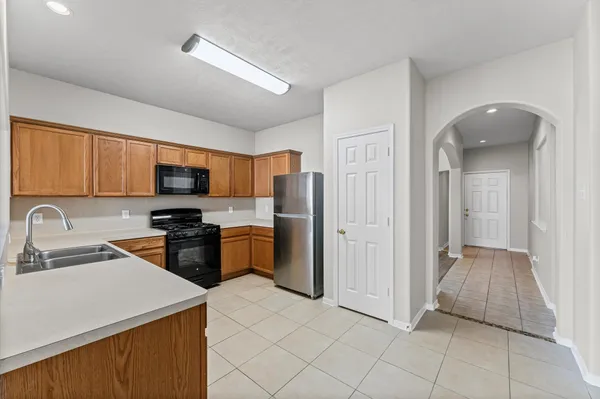 a kitchen with stainless steel appliances a refrigerator sink and microwave