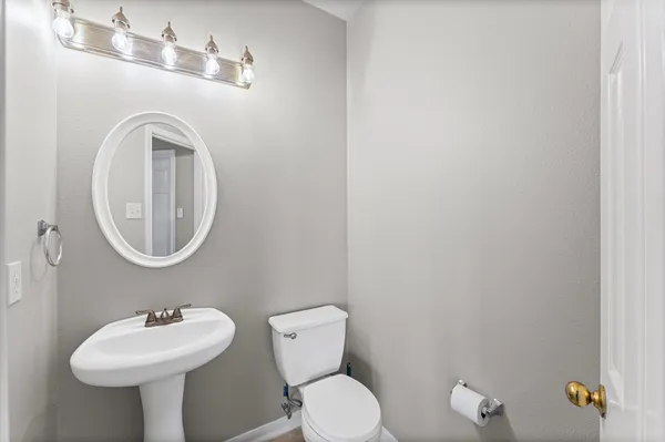 a bathroom with a toilet sink and mirror