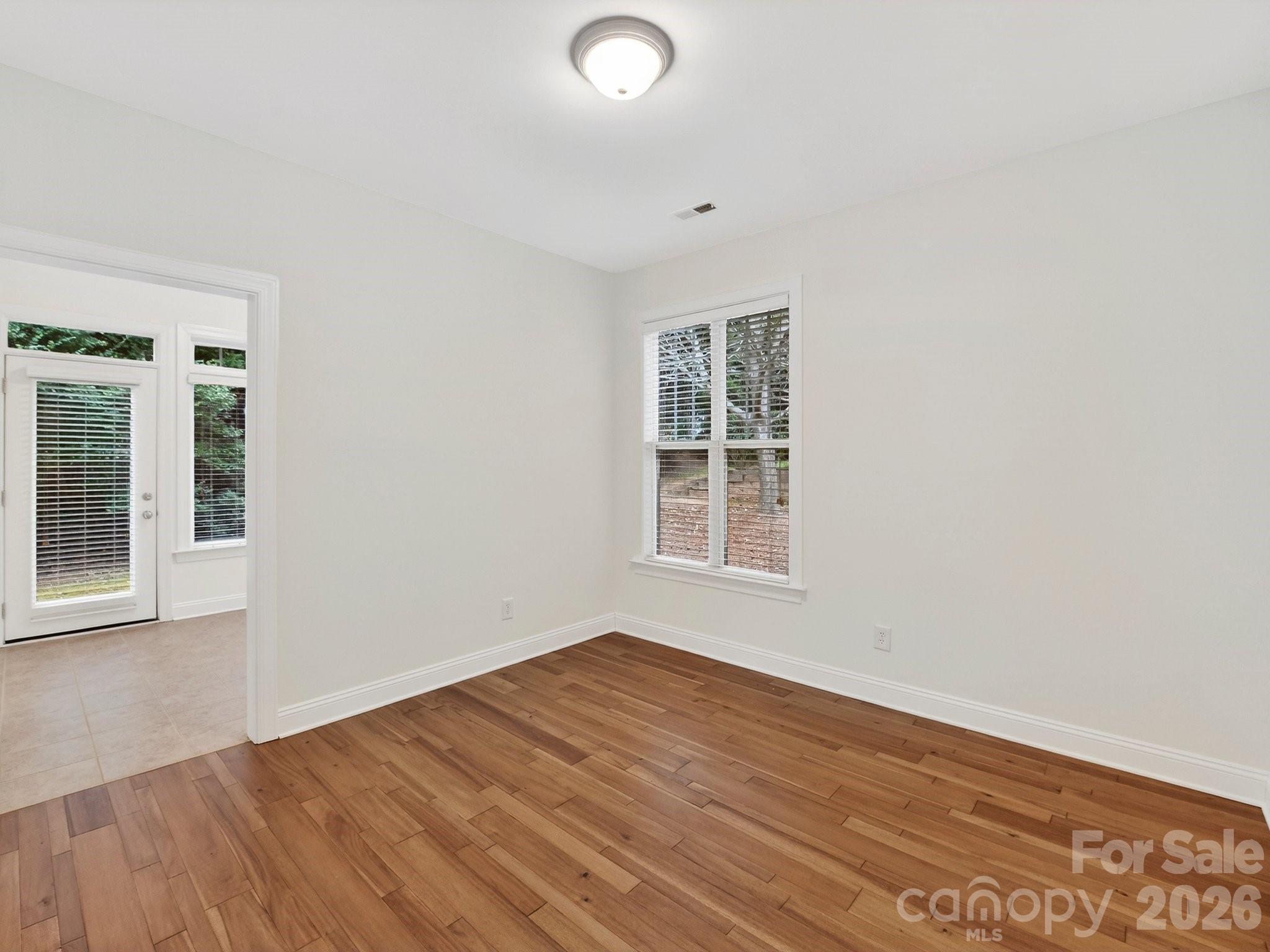 2963 Bellasera Way Matthews, NC 28105 - Photo 20 of 45 an empty room with wooden floor and windows