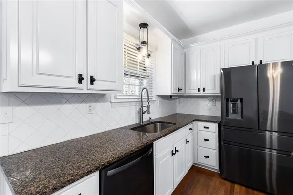 a kitchen with granite countertop white cabinets white appliances and sink