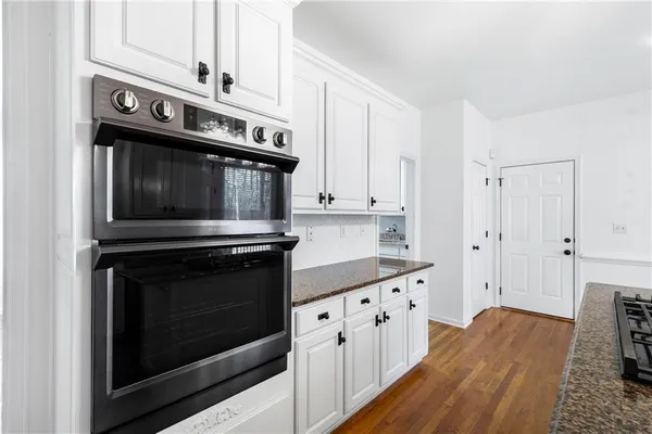 a kitchen with stainless steel appliances granite countertop a stove microwave and cabinets