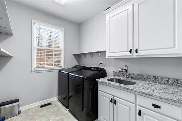 a kitchen with granite countertop white cabinets and a stove