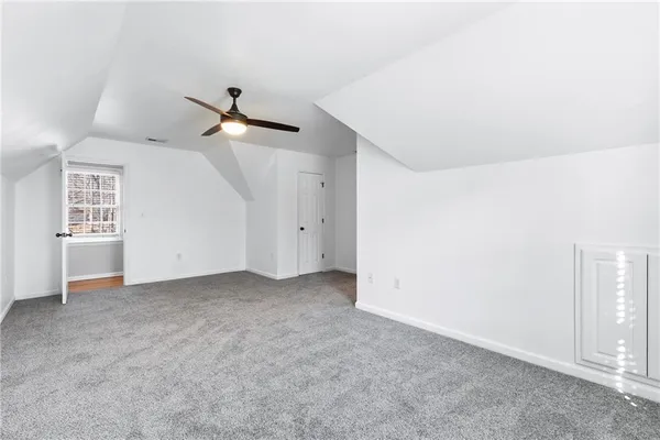 an empty room with ceiling fan and window