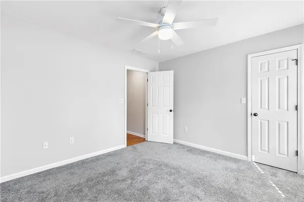 an empty room with a ceiling fan and a window
