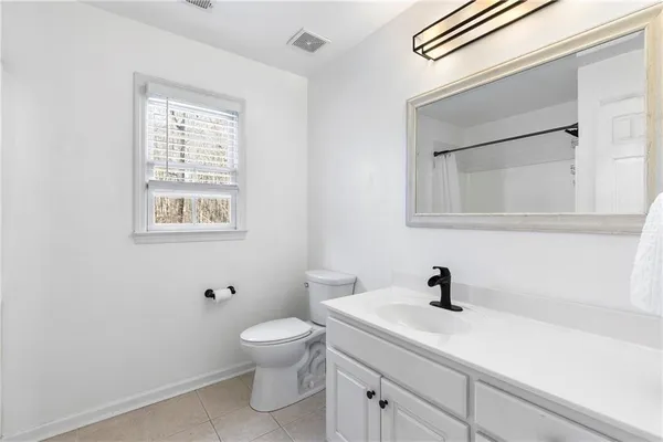 a bathroom with a toilet a sink and mirror
