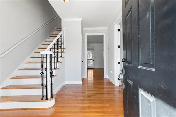 a view of a hallway with wooden floor and staircase