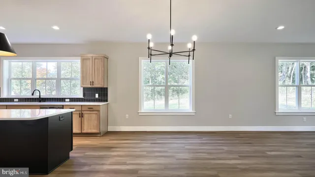 a kitchen with stainless steel appliances granite countertop a stove a sink a center island and a window