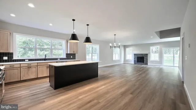 a large kitchen with granite countertop a large window a sink and stainless steel appliances