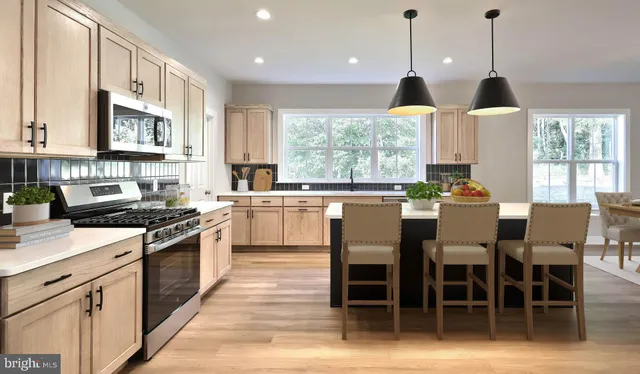 a kitchen with appliances cabinets and chair