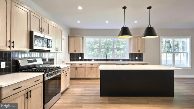 a kitchen with stainless steel appliances granite countertop a stove a sink and a microwave