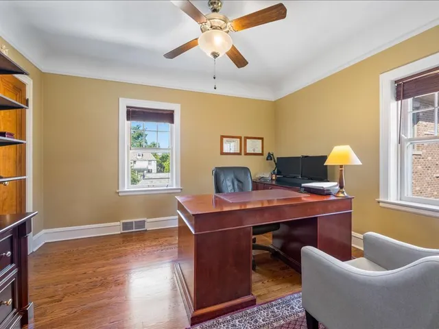 a view of a workspace with furniture and a window