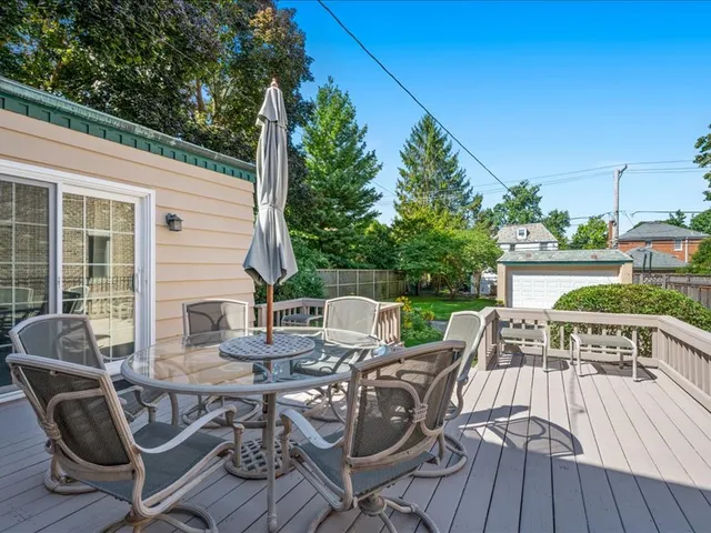 a view of a patio with table and chairs with wooden floor and fence