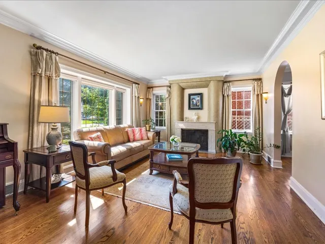 a living room with furniture fireplace and a large window