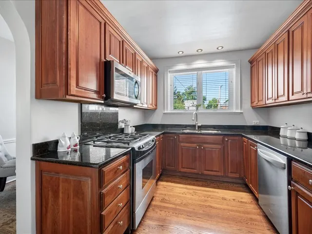 a kitchen with stainless steel appliances granite countertop a stove sink and cabinets