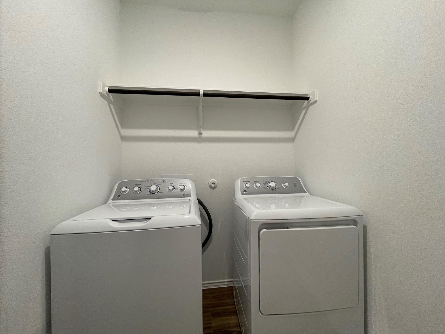 1625 Woolsey Way Leander, TX 78641 - Photo 10 of 17 Dedicated laundry area featuring a shelf and hanging rod, with a washing machine and dryer
