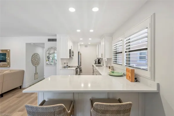 a view of kitchen with sink and refrigerator