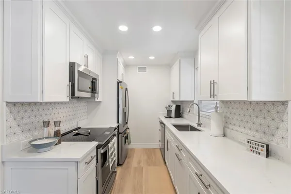 a kitchen with a sink stove top oven and cabinets