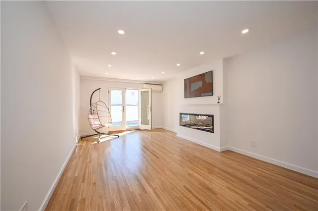 a view of an empty room with a fireplace and a window