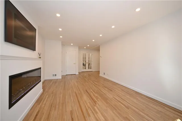 a view of empty room with wooden floor and fireplace