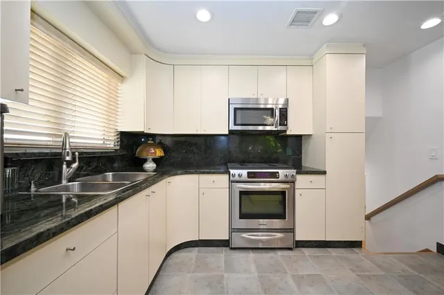 a kitchen with a sink a stove and cabinets