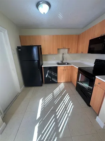 a kitchen with a refrigerator and a sink