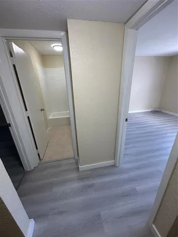 a view of a hallway with wooden floor and staircase